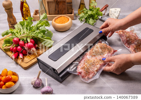 Woman vacuum sealing meat for food preservation Woman vacuum sealing meat for food preservation 140067389