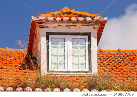 Dormer window on traditional red tiled roof in Portugal Dormer window on traditional red tiled roof in Portugal 140067769