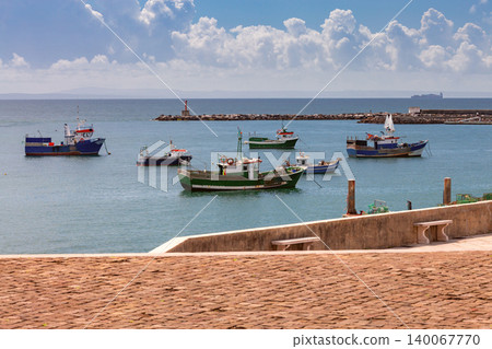 Fishing boats anchored in harbor near waterfront promenade Portugal 140067770