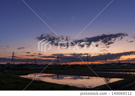 The Odakyu Line runs, its seasonal reflections mirrored in the water of the rice paddies. The Odakyu Line runs, its seasonal reflections mirrored in the water of the rice paddies. 140068512