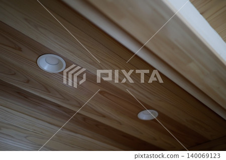 Downlights in a wood-grain ceiling. The room is dimly lit with the lights off. Lighting fixtures Downlights in a wood-grain ceiling. The room is dimly lit with the lights off. Lighting fixtures 140069123