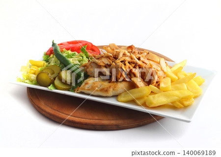 Turkish cuisine. Doner kebab meat with pommes frites potatoes and salad on plate isolated on white background 140069189