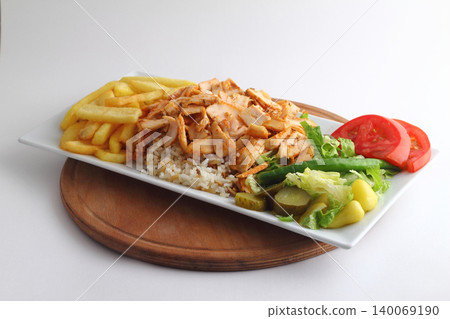 Turkish cuisine. Doner kebab meat with pommes frites potatoes and salad on plate isolated on white background 140069190