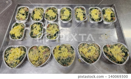 Freshly Prepared Spinach Gratin with Cheese and Ham in Foil Containers for Baking Freshly Prepared Spinach Gratin with Cheese and Ham in Foil Containers for Baking 140069300