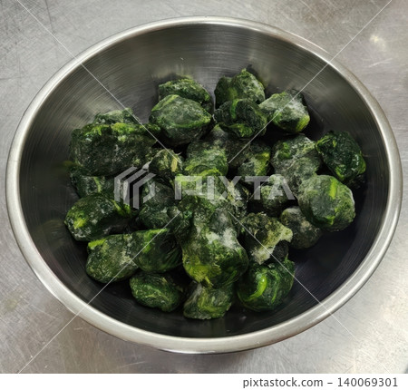Frozen Chopped Spinach Portions in a Stainless Steel Mixing Bowl on Kitchen Counter Frozen Chopped Spinach Portions in a Stainless Steel Mixing Bowl on Kitchen Counter 140069301
