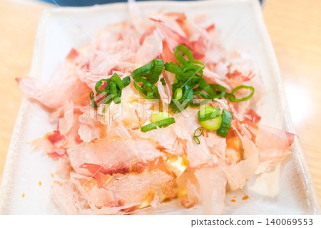 照片上是撒上鰹魚片的豆腐,這是一種很容易在居酒屋菜單上使用的小吃。 照片上是撒上鰹魚片的豆腐,這是一種很容易在居酒屋菜單上使用的小吃。 140069553