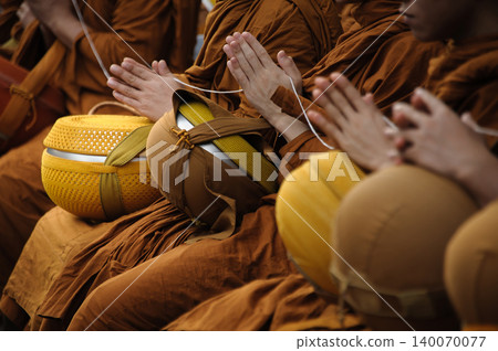 many monks press their hands together to pray before people give alms to the monk many monks press their hands together to pray before people give alms to the monk 140070077