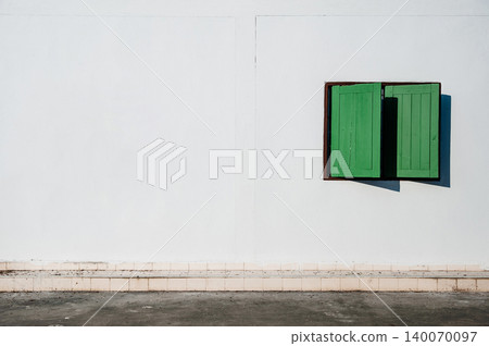 green wood window frame on white wall by walkway 140070097
