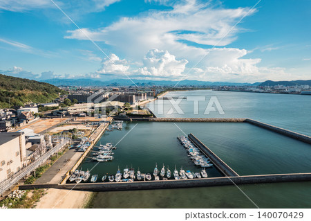 A summer fishing port with towering cumulonimbus clouds - drone aerial footage A summer fishing port with towering cumulonimbus clouds - drone aerial footage 140070429