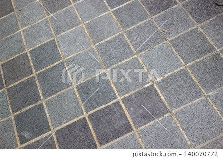Rough square gray andesite natural stone tiles with cement grout. Rough square gray andesite natural stone tiles with cement grout. 140070772