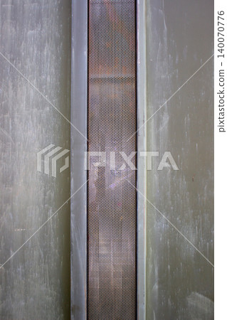 Rusted micro perforated iron plate ventilation panel on green gate. Rusted micro perforated iron plate ventilation panel on green gate. 140070776