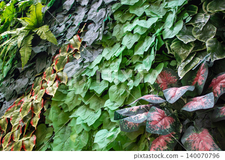 Green and red plastic plants arranged into an artificial garden. Green and red plastic plants arranged into an artificial garden. 140070796