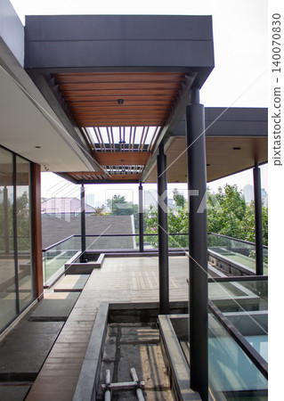 Upper balcony corridor with gray tile floor and wooden canopy. Upper balcony corridor with gray tile floor and wooden canopy. 140070830