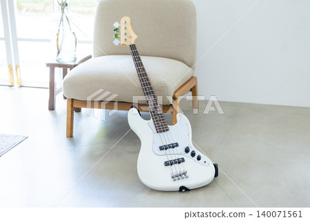 Hobbies: Musical instruments, a bass guitar leaning against a chair. 140071561