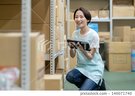 Middle-aged woman working in a warehouse Middle-aged woman working in a warehouse 140071740