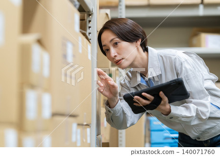 Middle-aged female worker in a warehouse Middle-aged female worker in a warehouse 140071760