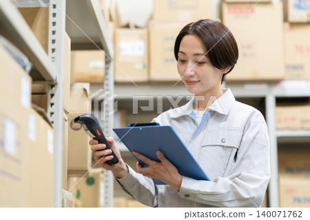 Middle-aged female worker in a warehouse Middle-aged female worker in a warehouse 140071762