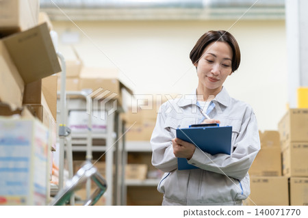 Middle-aged female worker in a warehouse Middle-aged female worker in a warehouse 140071770