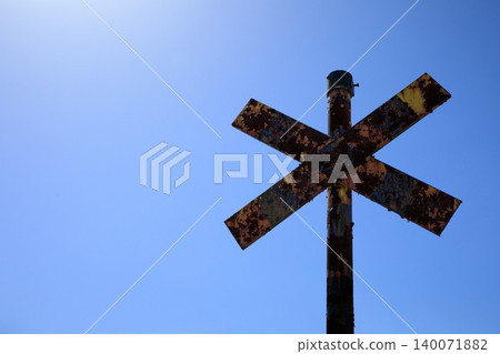 A rusty and dilapidated railroad crossing A rusty and dilapidated railroad crossing 140071882