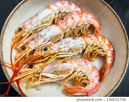 Top view of raw wild caught red argentine prawns with long antennae served in a rustic ceramic bowl on a dark background Top view of raw wild caught red argentine prawns with long antennae served in a rustic ceramic bowl on a dark background 140072746