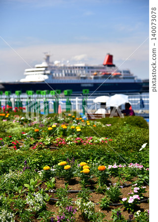 A beautiful large cruise ship viewed from the flowerbeds of Yamashita Park against the refreshing blue sky of early summer. A beautiful large cruise ship viewed from the flowerbeds of Yamashita Park against the refreshing blue sky of early summer. 140073078