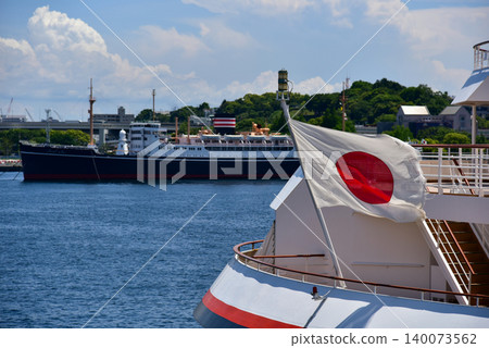Under a blue sky, the stern of the luxury cruise ship "Nippon Maru" and the Japanese flag are visible as the ship is docked in Yokohama Port. Under a blue sky, the stern of the luxury cruise ship "Nippon Maru" and the Japanese flag are visible as the ship is docked in Yokohama Port. 140073562