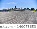 Under the blue sky, a wooden deck stretches out over Yokohama Port in the summer, creating a beautiful scene of luxury cruise ships. 140073653