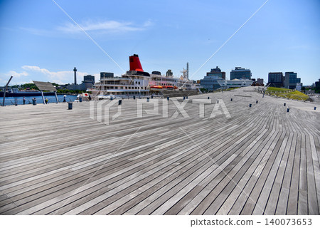 Under the blue sky, a wooden deck stretches out over Yokohama Port in the summer, creating a beautiful scene of luxury cruise ships. Under the blue sky, a wooden deck stretches out over Yokohama Port in the summer, creating a beautiful scene of luxury cruise ships. 140073653