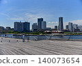 Under the blue sky, the Minato Mirai skyline can be seen from the wooden deck overlooking Yokohama Port. 140073654