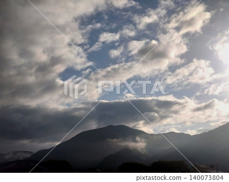 清晨,陽光穿透雲層,灑落在山巒之上。 清晨,陽光穿透雲層,灑落在山巒之上。 140073804