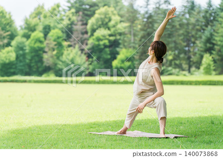 Young Asian women doing yoga, Pilates, and stretching in a park. 140073868