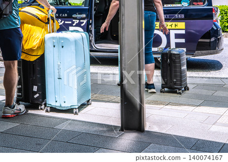 Foreign tourists riding in a Tokyo cityscape taxi... suitcases go into the rear trunk. 140074167