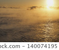 A ship sailing through the sea fog illuminated by the morning sun. 140074195