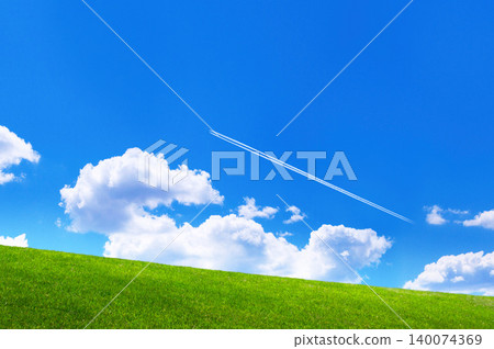 A landscape of green hills with a blue sky and white clouds. 140074369