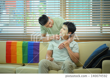 LGBTQ couple applying facial mask at home LGBTQ couple applying facial mask at home 140074592