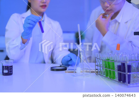 Test tubes with green and purple liquid samples in a laboratory rack, symbolizing scientific research, analysis, and experimental chemistry. 140074643
