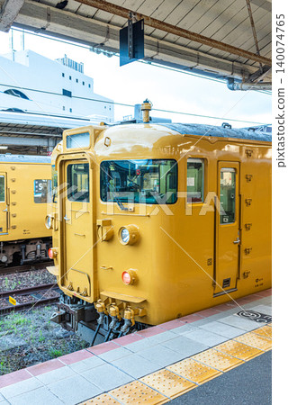 Yellow commuter train at railway station platform in Japan Yellow commuter train at railway station platform in Japan 140074765