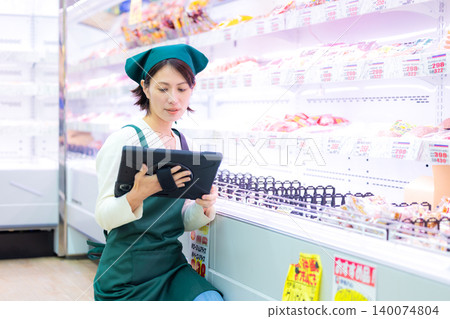 woman working in a supermarket woman working in a supermarket 140074804