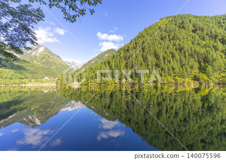 Amazing view of Mirror Lake with crystal clear water among mountains and evergreen woods in Jiuzhaigou nature reserve (Jiuzhai Valley National Park),China.  140075596