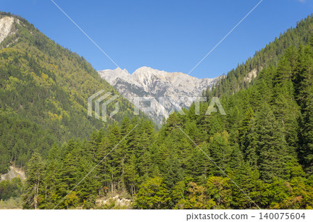 Amazing view of Mirror Lake with crystal clear water among mountains and evergreen woods in Jiuzhaigou nature reserve (Jiuzhai Valley National Park),China. Amazing view of Mirror Lake with crystal clear water among mountains and evergreen woods in Jiuzhaigou nature reserve (Jiuzhai Valley National Park),China. 140075604