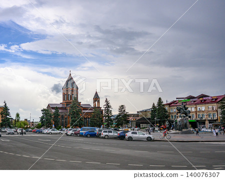 Urban scene featuring church, cars, and people in city square Urban scene featuring church, cars, and people in city square 140076307
