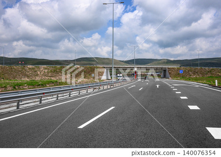 Asphalt road leads to tunnel with cars passing Asphalt road leads to tunnel with cars passing 140076354