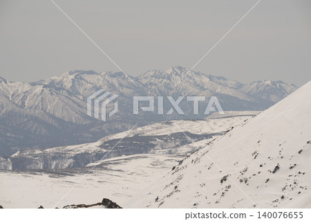Snow-covered ridges and slopes of Mt. Asahidake in Hokkaido, a panoramic view of the mountains shrouded in spring mist. Snow-covered ridges and slopes of Mt. Asahidake in Hokkaido, a panoramic view of the mountains shrouded in spring mist. 140076655