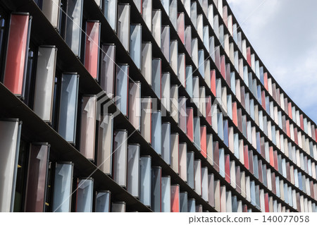 Modern curved office building facade with geometric window pattern Modern curved office building facade with geometric window pattern 140077058