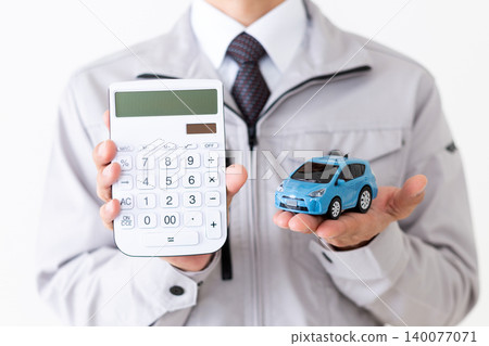 身穿灰色工作服的中年商人,手持模型車和計算器,背景為白色。 身穿灰色工作服的中年商人,手持模型車和計算器,背景為白色。 140077071