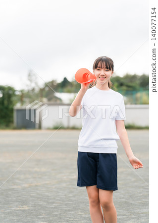 國中、高中和小學的女生穿著運動服拿著擴音器歡呼 國中、高中和小學的女生穿著運動服拿著擴音器歡呼 140077154