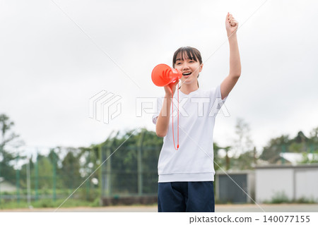 國中、高中和小學的女生穿著運動服拿著擴音器歡呼 國中、高中和小學的女生穿著運動服拿著擴音器歡呼 140077155