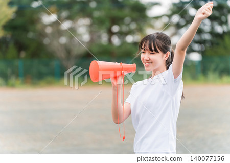 國中、高中和小學的女生穿著運動服拿著擴音器歡呼 國中、高中和小學的女生穿著運動服拿著擴音器歡呼 140077156