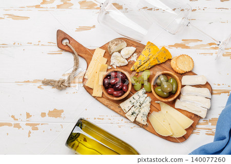 Cheese board with assorted cheeses and olives Cheese board with assorted cheeses and olives 140077260