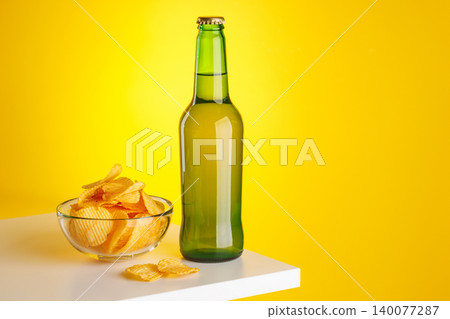 Beer bottle and chips on yellow background snack setup Beer bottle and chips on yellow background snack setup 140077287